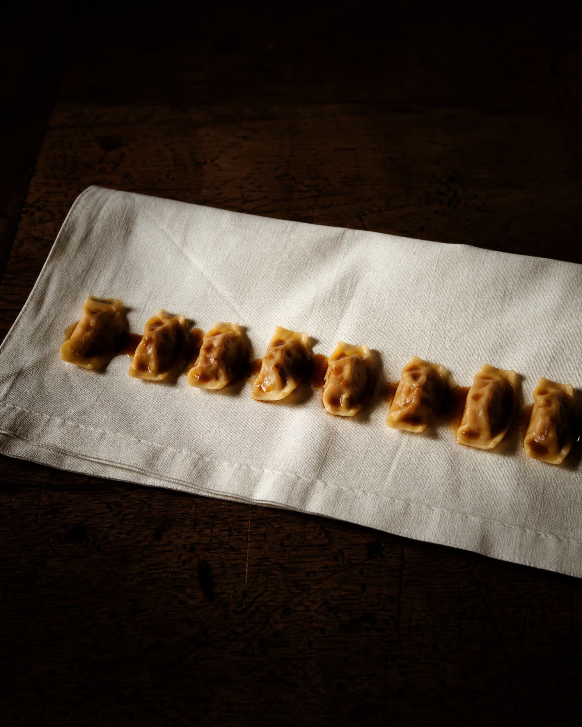 Agnolotti dal plin on a linen napkin, dressed only in roasting juices.